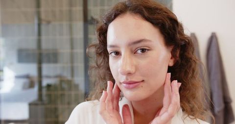 Woman Embracing Self-Care Ritual in Modern Bathroom