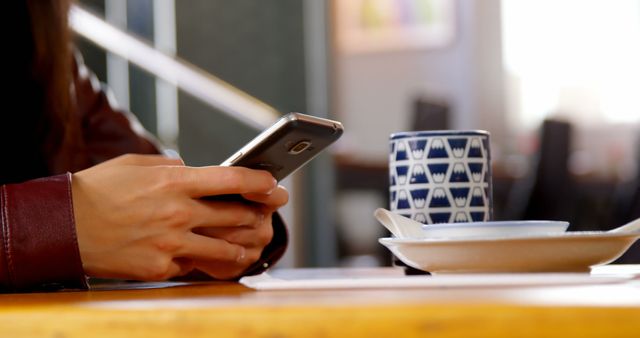 Person Texting with Smartphone in Cozy Cafe - Download Free Stock Images Pikwizard.com