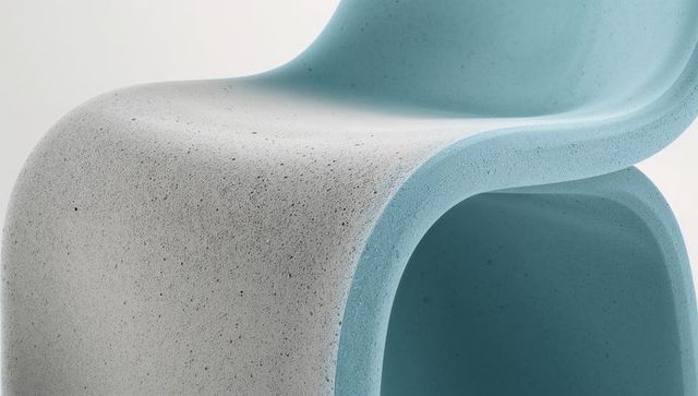 Sculptural s-curve chair with speckled terrazzo surface and blue hollow channel