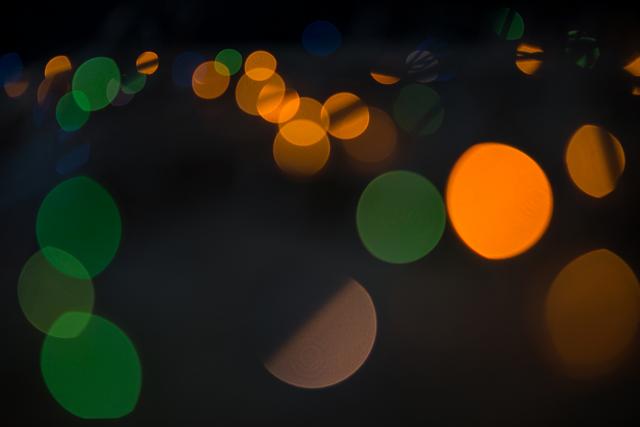 Abstract bokeh lights in various colors create a festive and vibrant atmosphere, perfect for holiday-themed designs, greeting cards, and festive marketing materials. The blurred circles of light evoke a sense of warmth and celebration, ideal for use in Christmas promotions and seasonal advertisements.