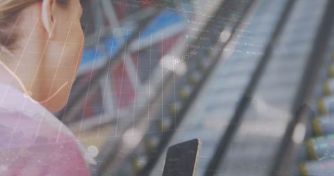 Woman Engaged with Smartphone Over Stock Market Graphs on Escalator