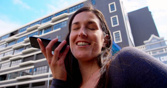 Smiling Woman Using Voice Control on Smartphone in Urban Setting - Download Free Stock Images Pikwizard.com