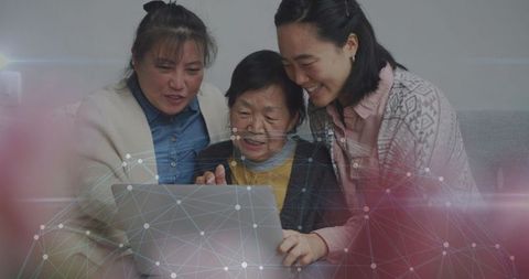 Multigenerational women smiling while learning on laptop with digital network overlay