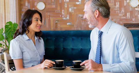Diverse Colleagues Enjoying Conversation Over Coffee in Cafe