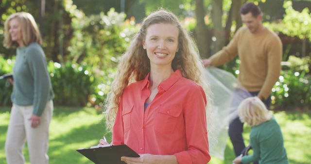 Cheerful Woman Holding Clipboard in Family Garden - Download Free Stock Images Pikwizard.com