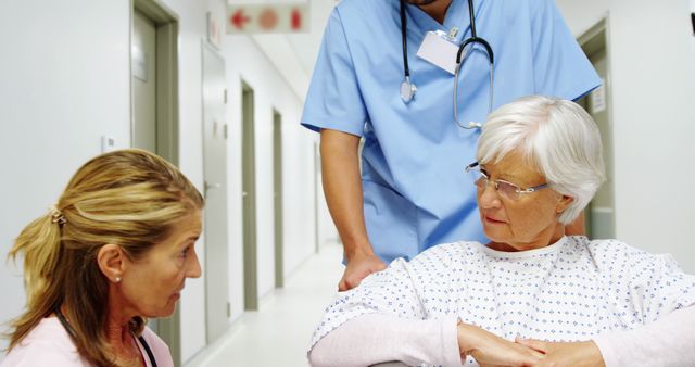 Nurse Assisting Senior Woman in Hospital Hallway with Concerned Family Member - Download Free Stock Images Pikwizard.com