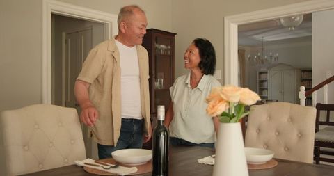 Senior Asian Couple Setting Dining Table for Family Meal