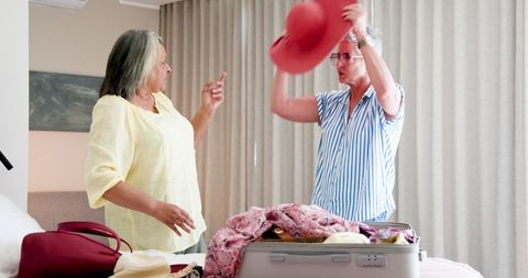 Senior lesbian couple joyfully packing for vacation