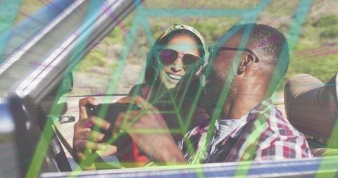 Smiling couple enjoying convertible road trip with neon geometric overlay and phone