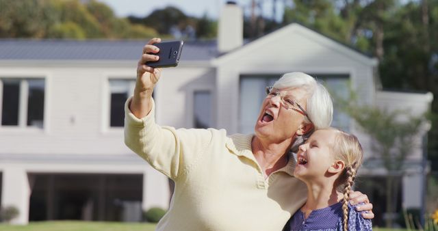Grandmother and granddaughter sharing fun moment taking selfie outdoors - Download Free Stock Images Pikwizard.com