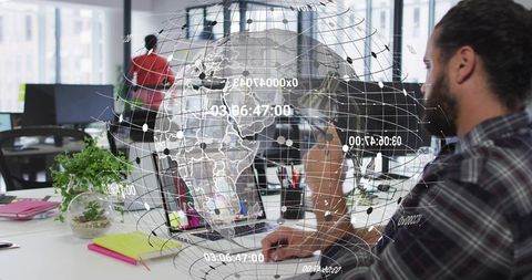 Software engineer analyzing data with holographic globe in modern office