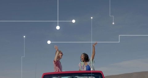 Two Women Enjoying Convertible Ride on Rural Road with Tech Overlay