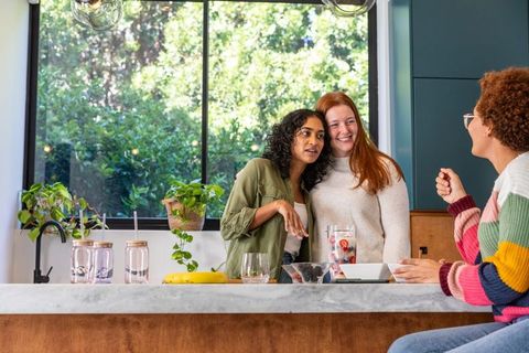 Diverse Female Friends Enjoying Healthy Drinks in Modern Kitchen