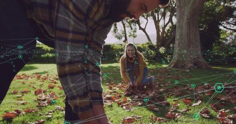 Couple gathering autumn leaves with teal network overlay showing smart connectivity