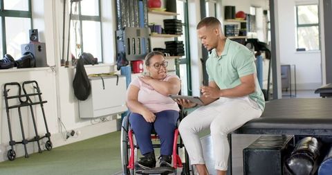 Rehabilitation Therapy Discussion with Woman in Wheelchair