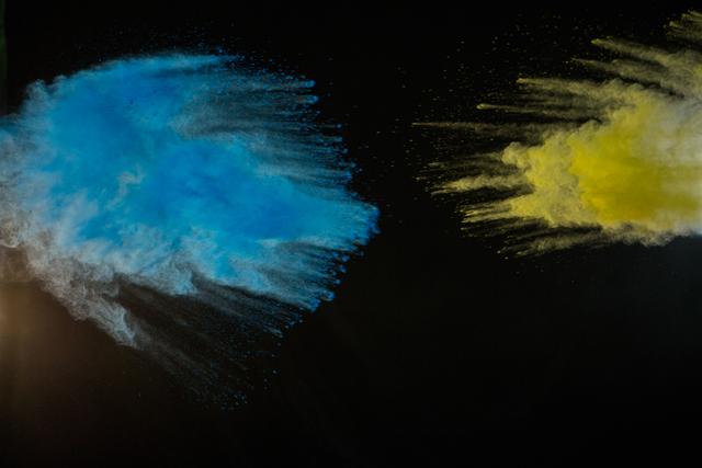 Blue and yellow color powder exploding against a black background, creating a vibrant and dynamic visual effect. Ideal for use in creative projects, advertisements, festival promotions, artistic designs, and backgrounds for digital content.