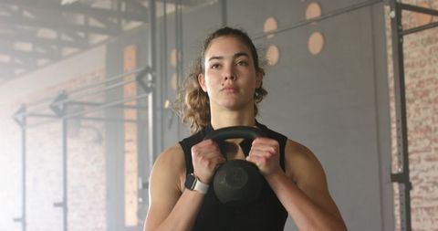 Female Athlete Practicing with Kettlebell in Industrial Gym Setting