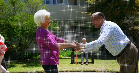 Joyful Seniors Dancing Under Sparkling Lights Outdoors