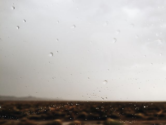 Rain Droplets on Window with Overcast Sky and Distant Landscape - Download Free Stock Photos Pikwizard.com