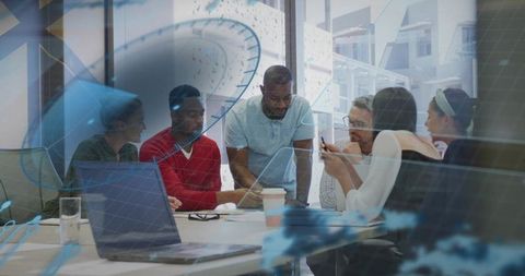 Diverse team collaborating around conference table with leader pointing and discussing