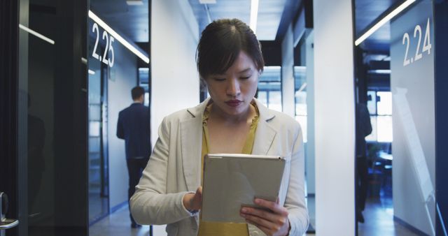 Focused Businesswoman Using Tablet in Modern Office Hallway - Download Free Stock Images Pikwizard.com