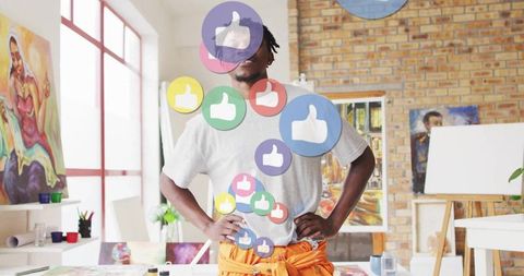 Artist in studio with floating thumbs-up icons
