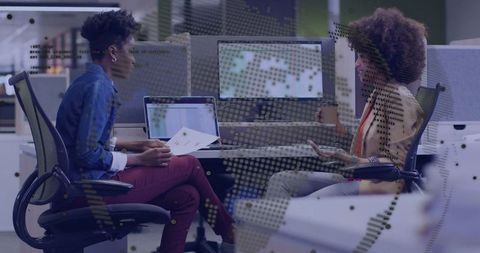 Colleagues Discussing Reports in Modern Open-Plan Office