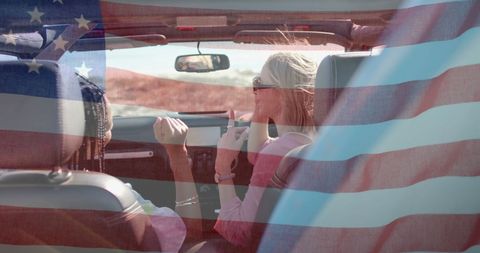 Diverse Women Driving Convertible by Coast with American Flag Overlay