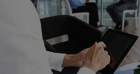 Business professional using tablet in modern office lounge