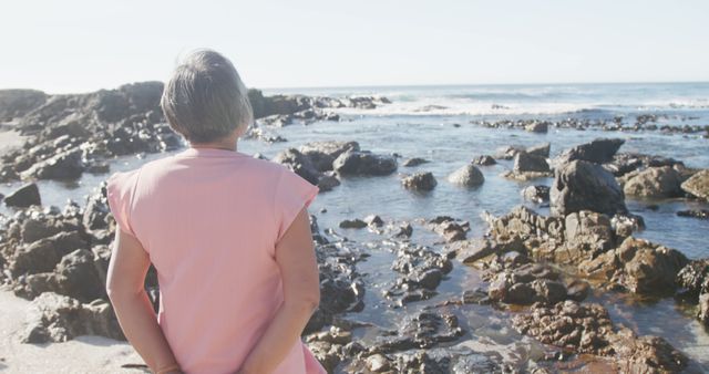 Senior Woman Enjoying Ocean View on Rocky Beach - Download Free Stock Images Pikwizard.com