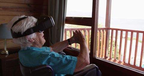Senior Woman in Wheelchair Using Virtual Reality Headset at Home