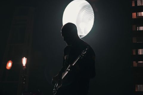 Silhouette of Musician with Bass Guitar on Illuminated Stage