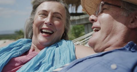 Happy Senior Couple Relaxes in Hammock on Beach Vacation
