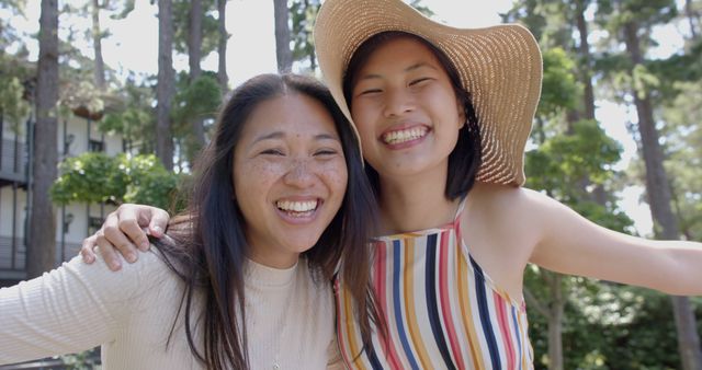 Smiling Asian women embracing outdoors at park - Download Free Stock Images Pikwizard.com