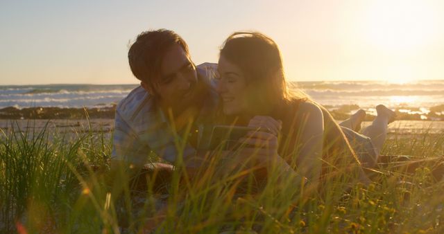 Romantic couple discussing on mobile phone on beach. Couple having fun on beach during sunset 4k