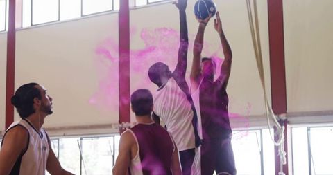 Athletic Basketball Players Leaping with Pink Powder Trail in Gym
