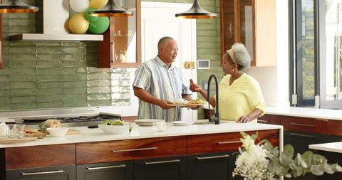 Senior Couple Bonding in Sunlit Kitchen with Balloons