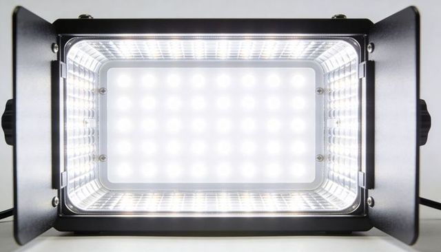 Bright led flood light with barn doors illuminating studio panel and reflector