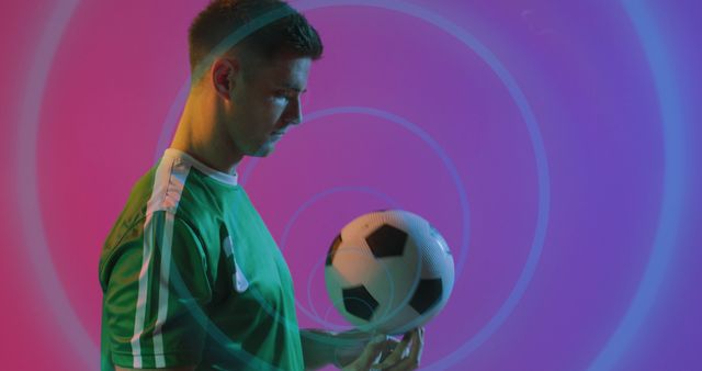 Male athlete in soccer uniform balancing soccer ball against vibrant, colorful background. Great for depicting sports, skill, athleticism, or vibrant promotional material related to soccer or active lifestyle.