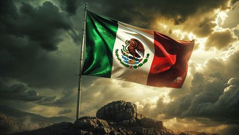 Majestic mexican flag waving on mountainous landscape