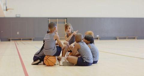 Diverse Children's Basketball Team Collaborating in Gym