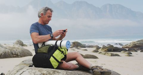 Senior Man Relaxing on Beach During Coastal Hike