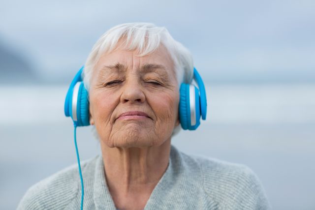 Close-up of senior woman listening to music on headphones
