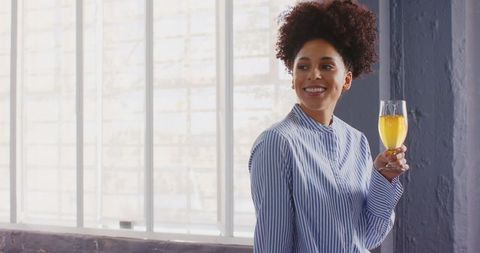African American Woman Enjoying Juice by Window in Casual Setting