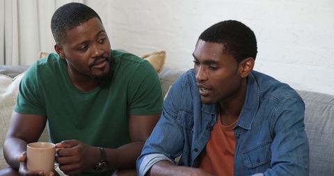 Friends relaxing and chatting on comfortable sofa