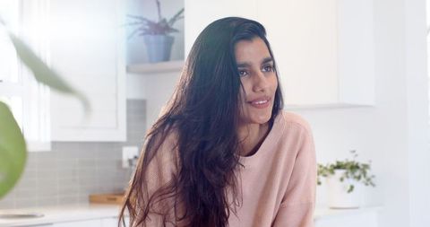 Woman in Minimalist Kitchen Admiring Modern Interiors