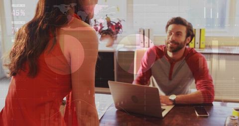 Hispanic woman leaning and leading team meeting with colleague at laptop analytics overlay