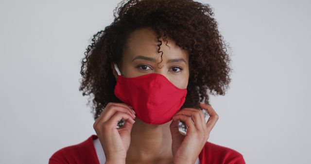 Portrait of biracial woman putting mask on. health and hygiene in a professional kitchen during coronavirus covid 19 pandemic.