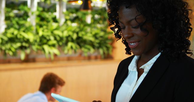 Businesswoman Using Digital Tablet in Modern Office with Greenery - Download Free Stock Images Pikwizard.com