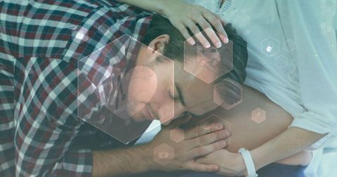 Man Embracing Pregnant Partner with Medical Icons Overlay